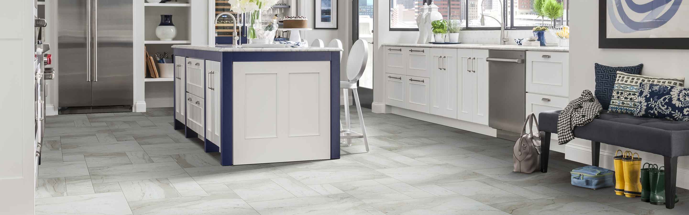 marble tile flooring in modern white kitchen with blue accents and stainless steel appliances